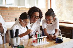 Teacher assisting students with science project
