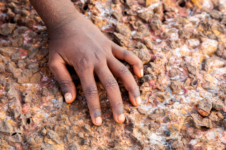 Single hand of a Young Indigenous girl on the rocks