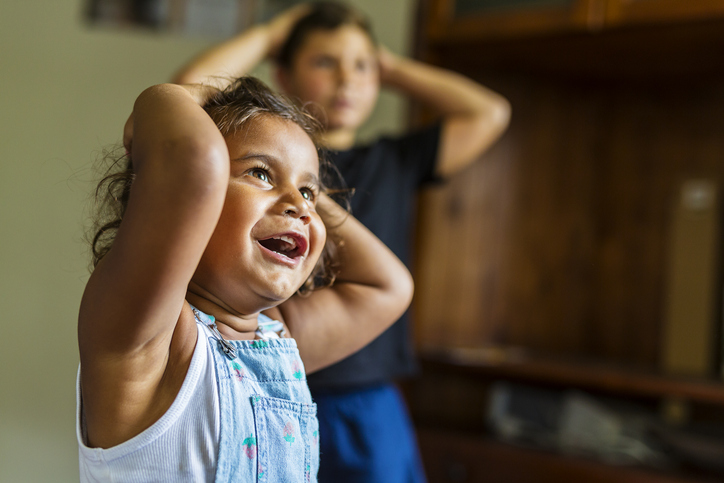 Happy Young Australian Aboriginal Girl smiling as she puts her hands on her head