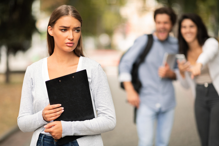 Two university students bullying a third student.