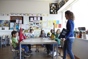 Child raising hand in classroom
