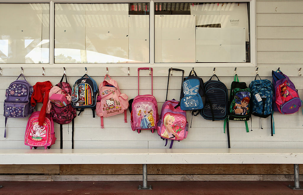 Schoolbags are hanging on the wall