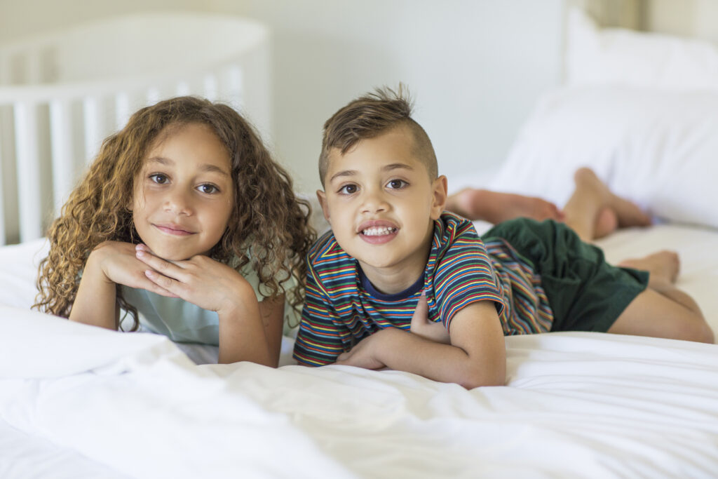 Portrait of aboriginal children brother and sister laying on a bed