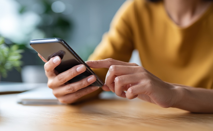 Office worker using smartphone at desk