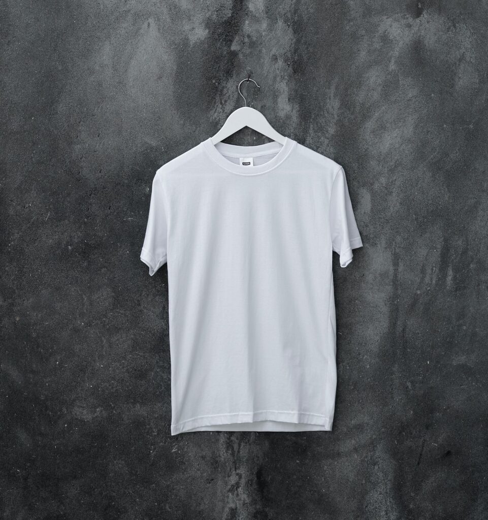 white t shirt hanging on concrete grey wall