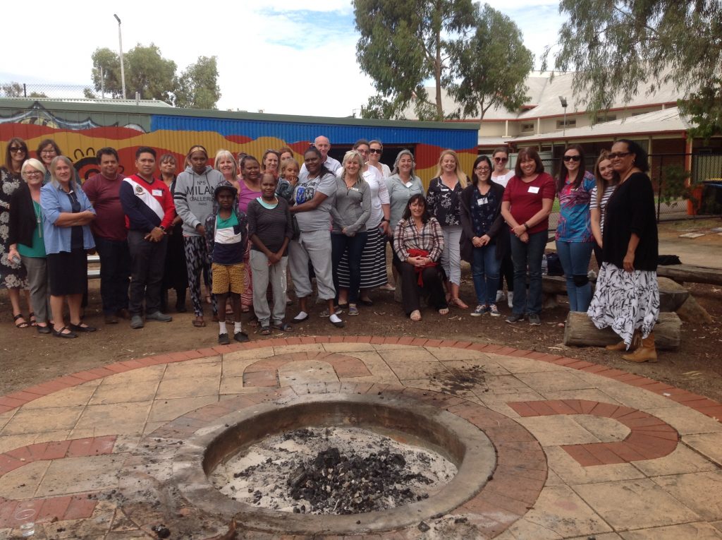 YDC staff, PRIME Futures participants and community members gather around fire pit